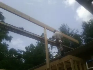 Carpenter setting a ridge beam over a new addition frame — Ice Dam Removal by Roofing Brothers in Haysville
