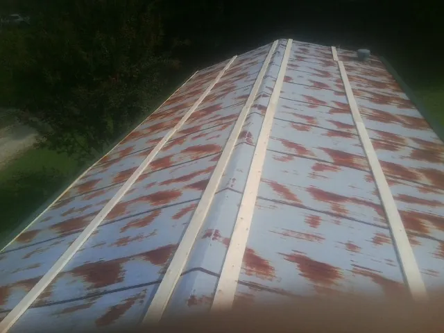 Rusted metal roof panels with new wood purlins before replacement — Storm Damage Roof Repair in Haysville by Roofing Brothers