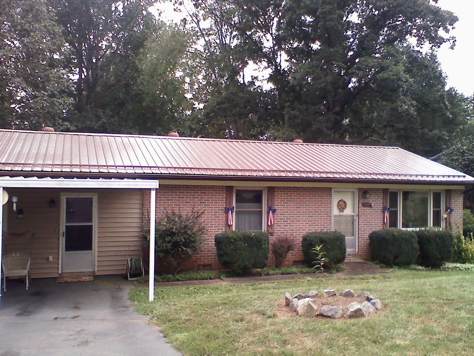 Bronze metal roof and carport on a brick ranch home — Roof Repair work by our crew in Haysville