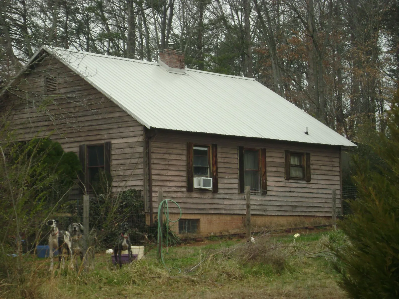 White metal roof on an old wood sided farmhouse, from a Metal Roof Installation job in Haysville